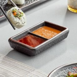 Acopa Heika 1 Oz. Black Matte Textured Rectangular 2-Compartment Stoneware Sauce Dish - 12/Case